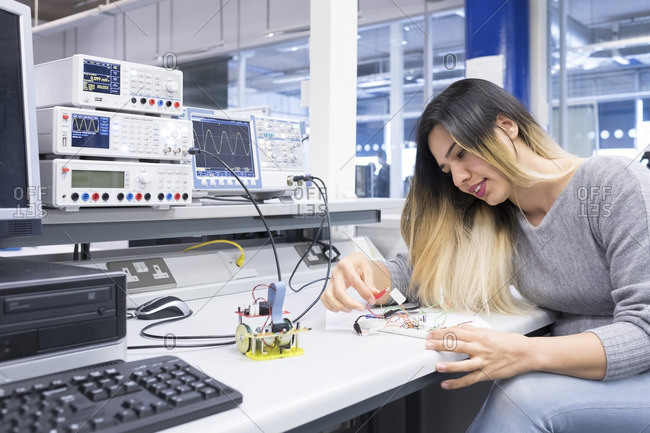 A female electronics student studying in an electronics engineering lab.
