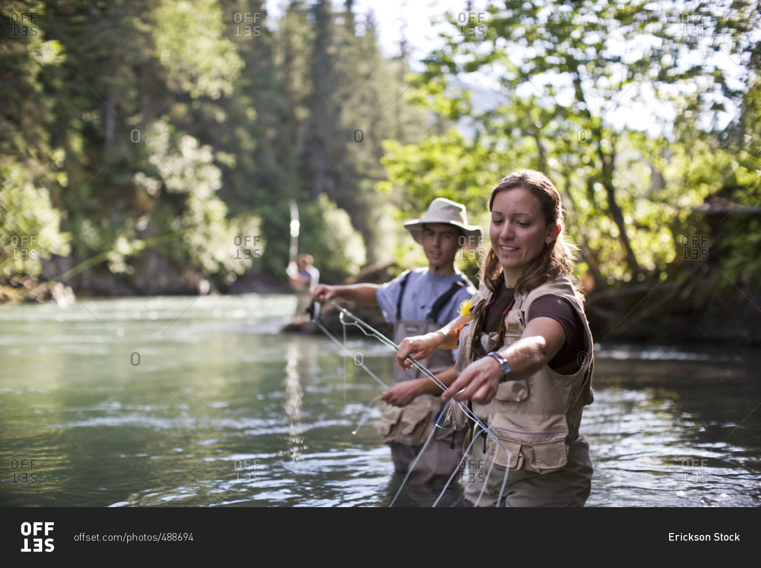 People fly fishing in a scenic forest.