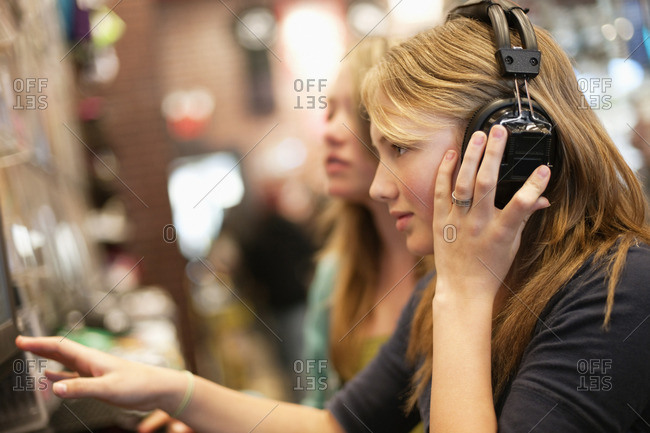 Teenage girls listening to music in a music shop.