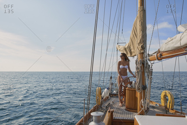 Beautiful Woman Steering Luxury Sailboat In Ocean Stock Photo Offset