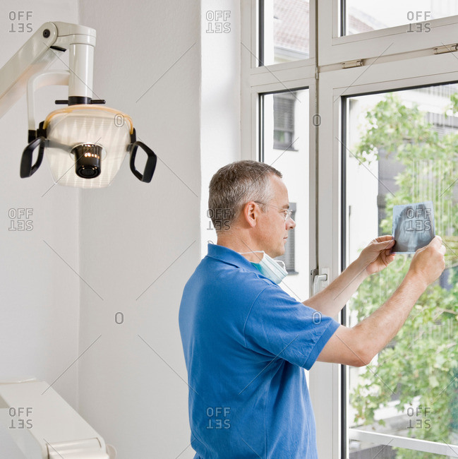 Male dentist looking at x-rays