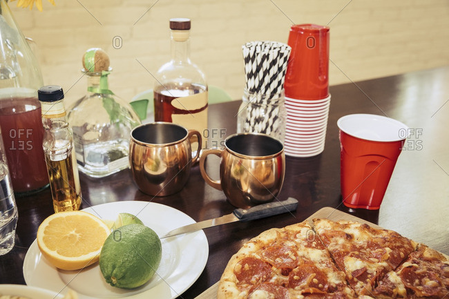 Pizza and ingredients for mixed drinks on a table at a party