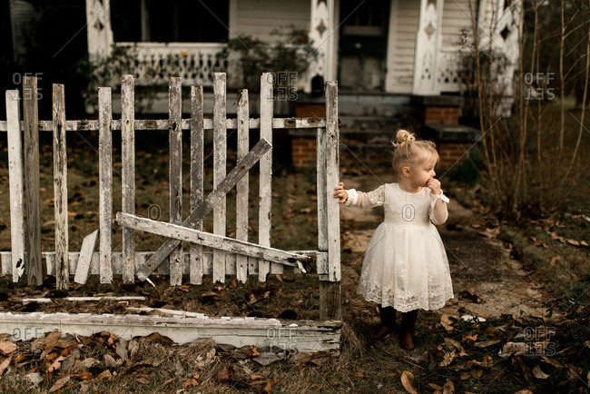 Toddler girl in front of an old country house