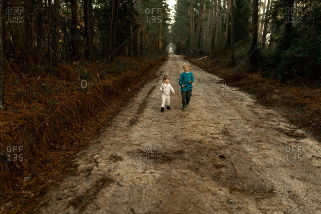 Two brothers walking down a dirt road