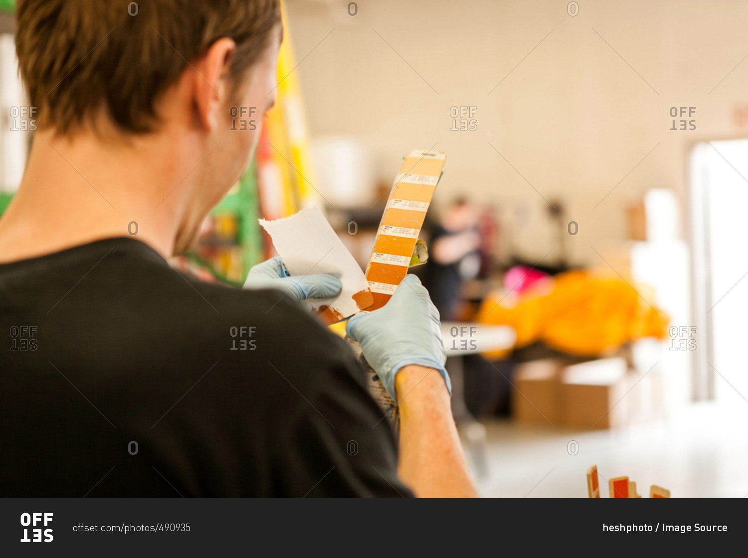 Worker looking at swatch in screen print workshop