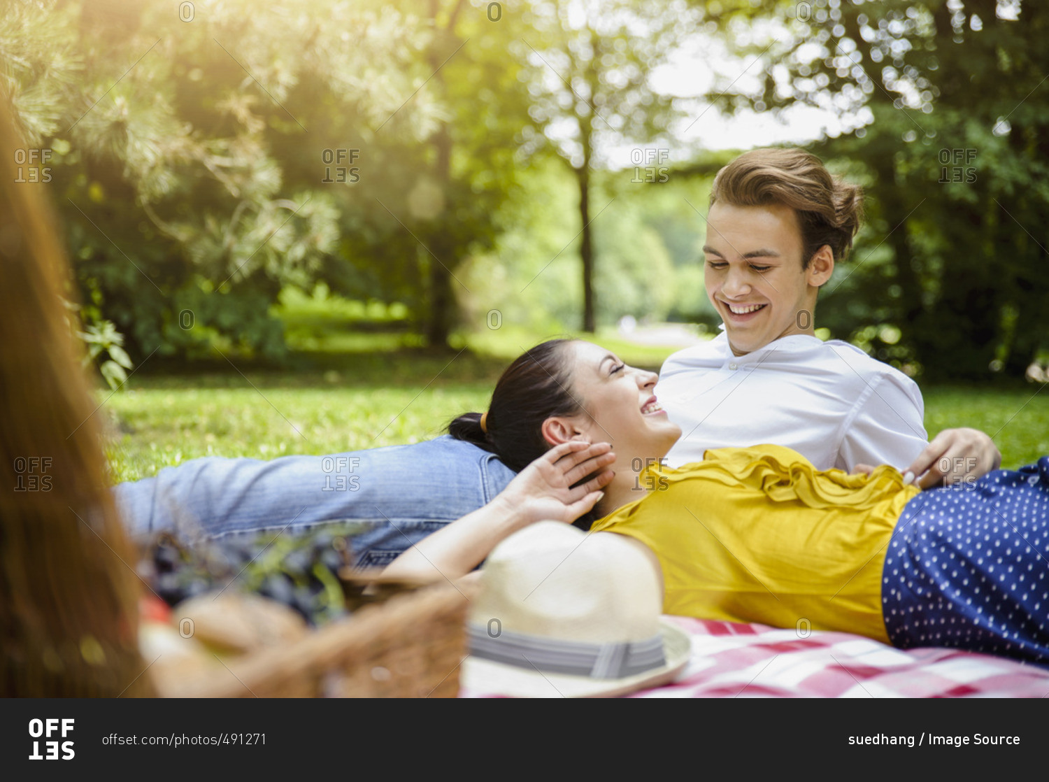 Young couple lying together on picnic blanket