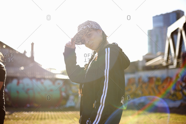 Cheerful young man wearing red bandana while looking away in city stock  photo - OFFSET