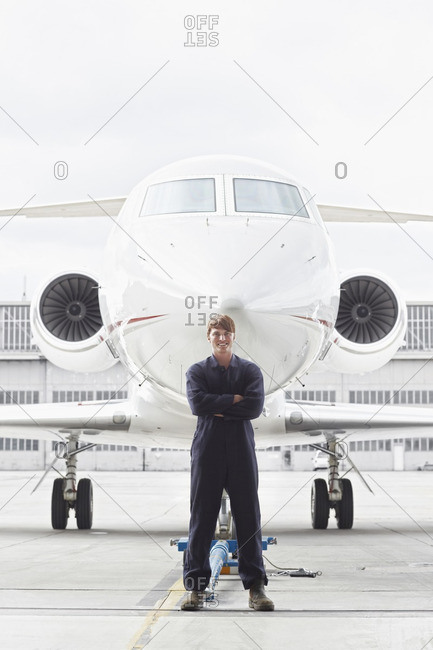 Caucasian flight engineer standing near jet