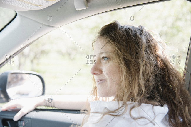 Woman seated in the front seat of a car.