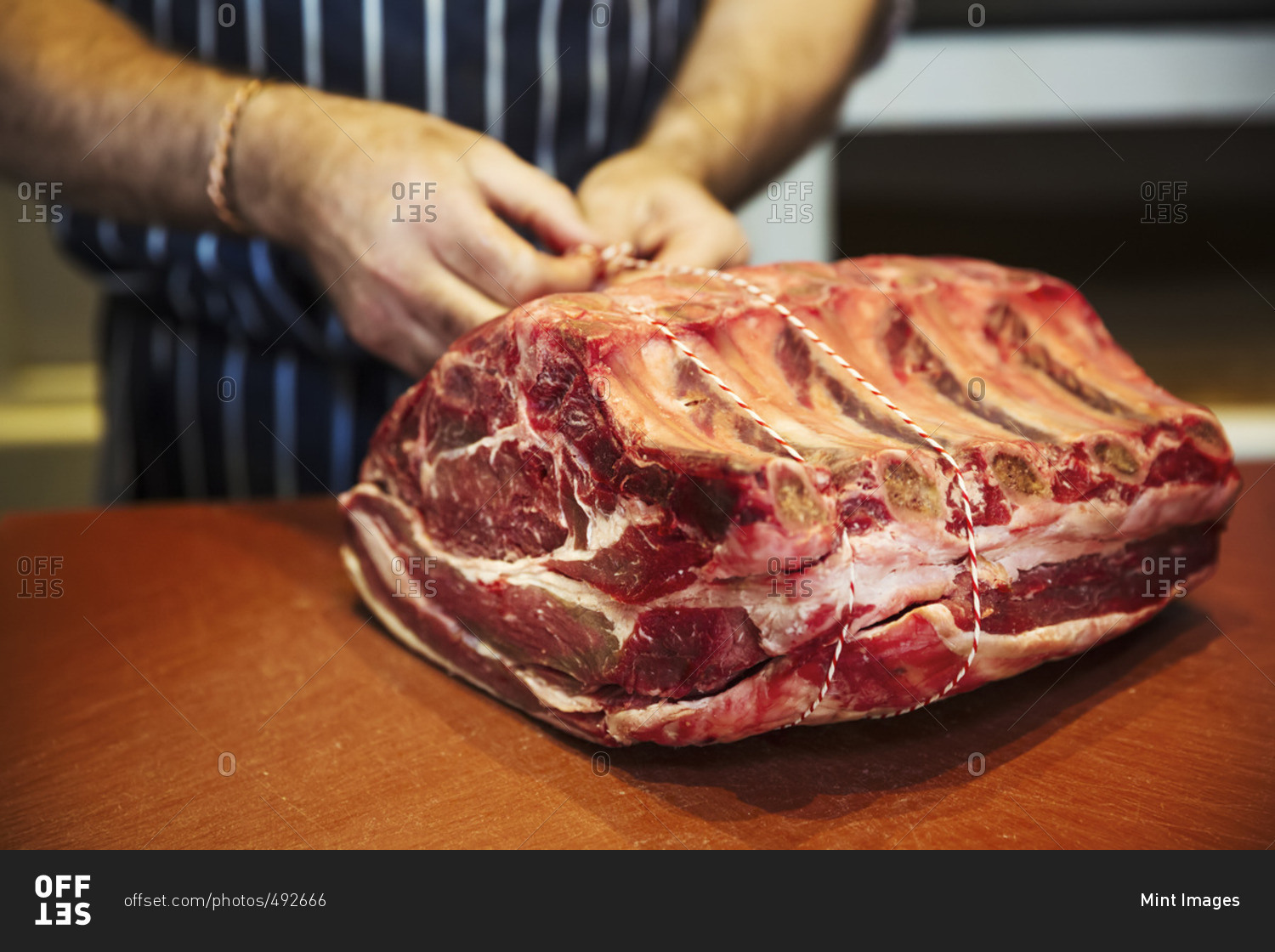 Butcher preparing a large piece of beef in a butcherer\'s shop.