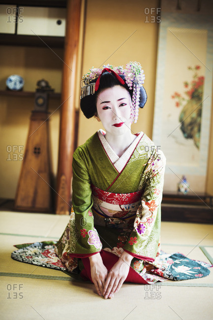 A woman dressed in the traditional geisha style, wearing a kimono and obi