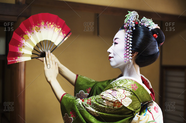 A woman dressed in the traditional geisha style, wearing a kimono and obi