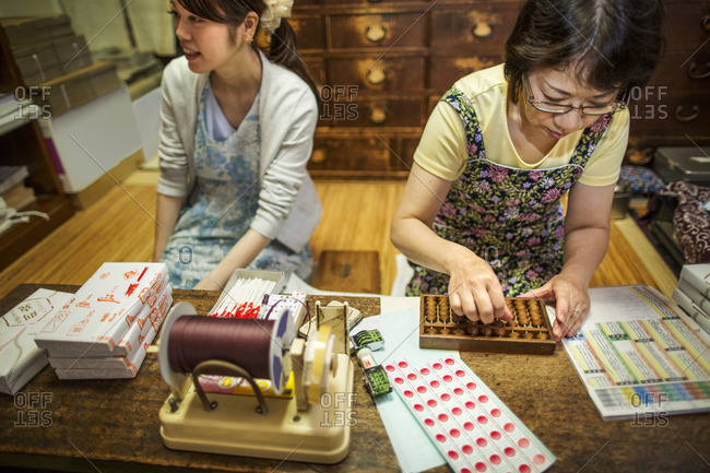 A small artisan producer of specialist treats, sweets called wagashi. Two women working packing sweet boxes for delivery.