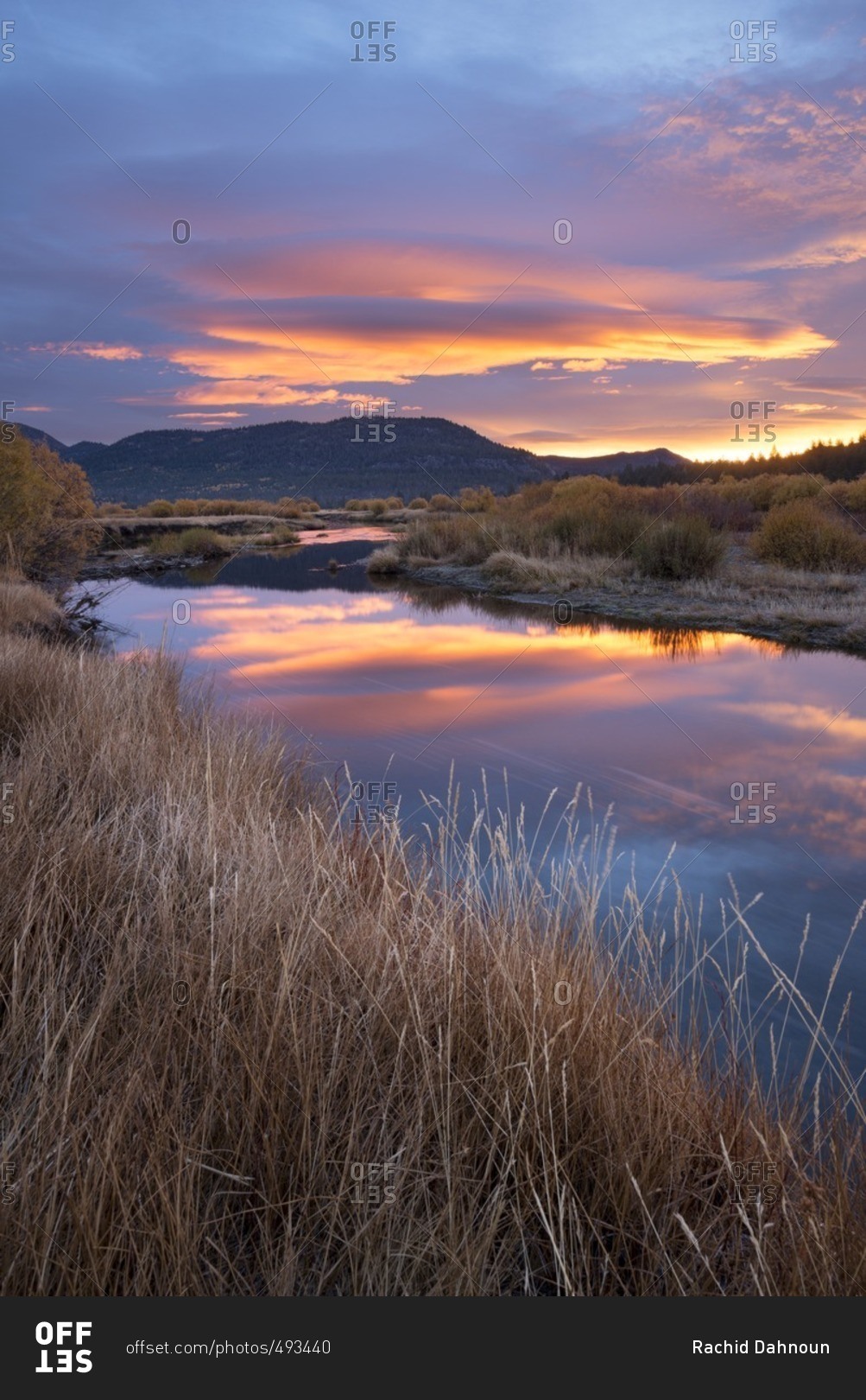 A beautiful sunrise reflects in the West Fork Carson River in the fall in Hope Valley, California.