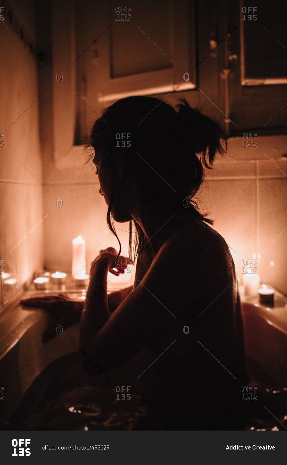 Relaxing Woman In Bath With Burning Candles Near by Stocksy Contributor  Sergey Narevskih - Stocksy