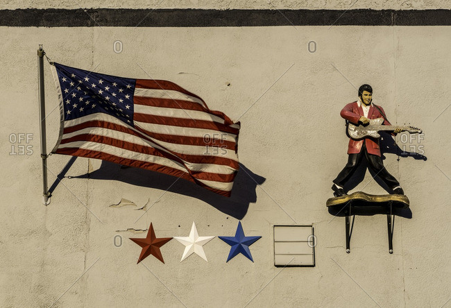 Yankton, South Dakota, USA - July 15, 2016: American flag and statue of Elvis on display on side of building