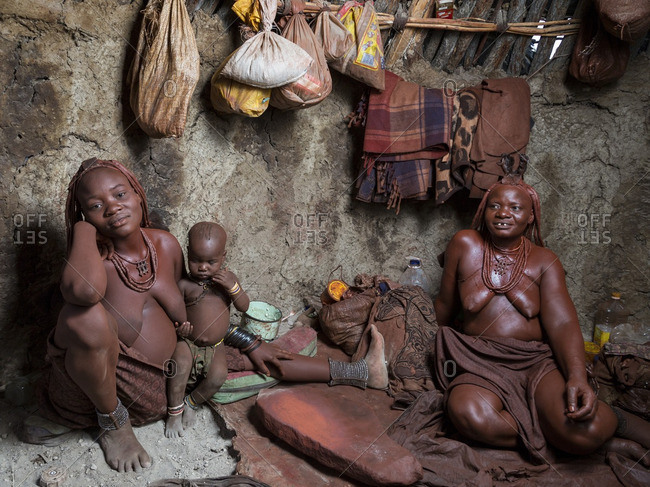 Namibia, Africa - May 30, 2014: Three generations of nimbi in a traditional mud hut in northern Namibia