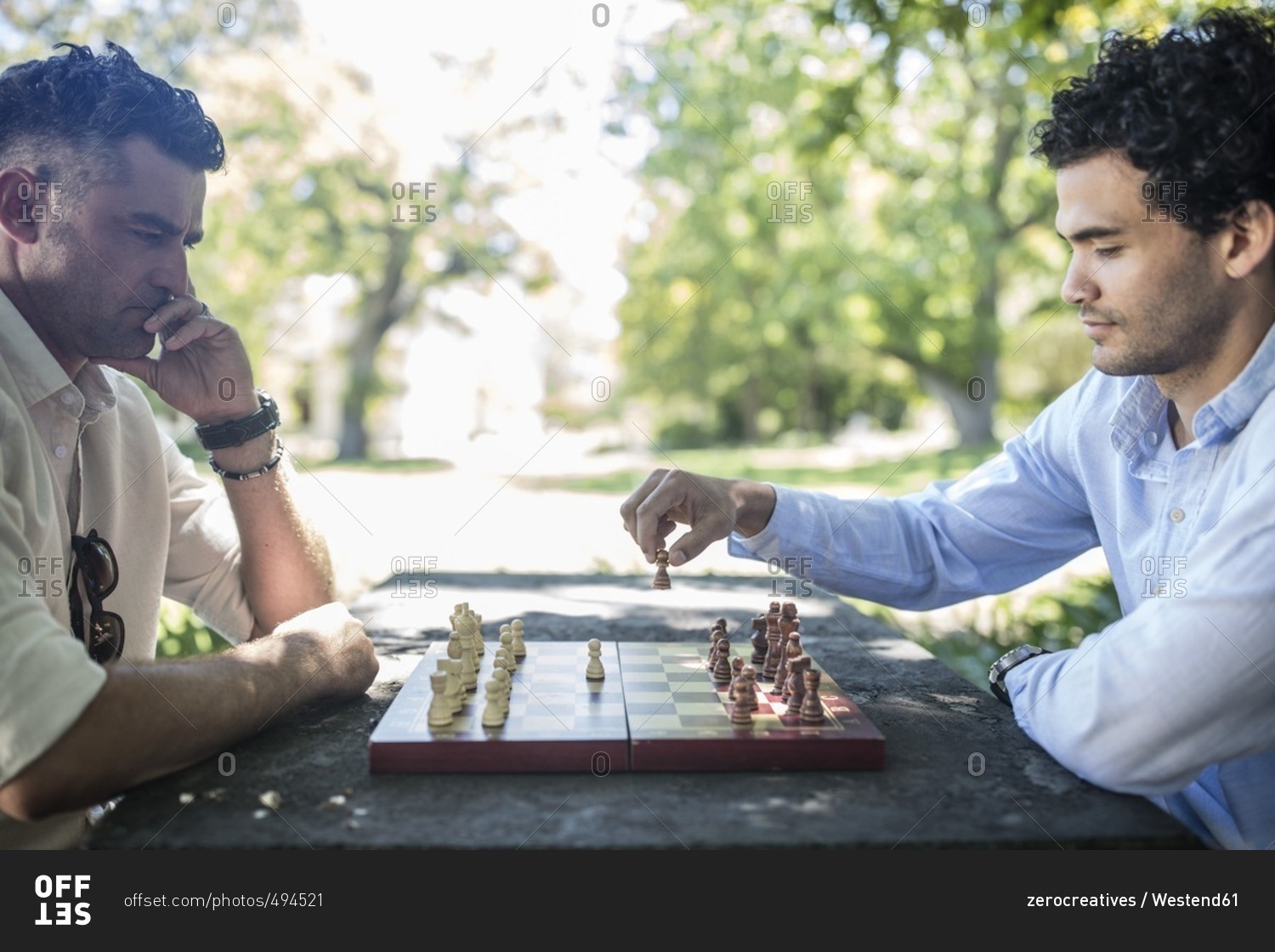 Men playing. Chess in the Park. Men playing Chess with cap.