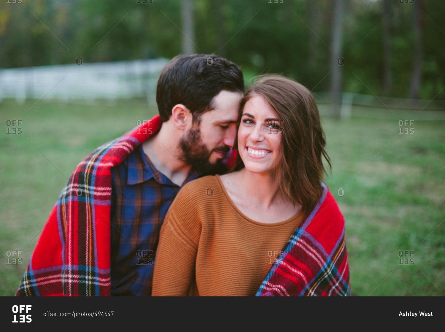 Smiling woman with man under blanket