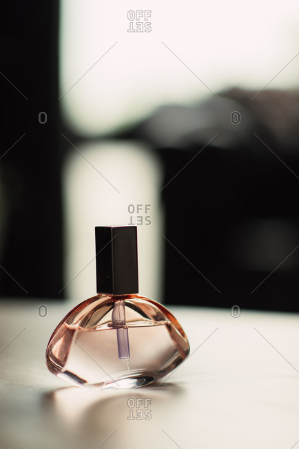 Close up of a rose colored bottle of perfume