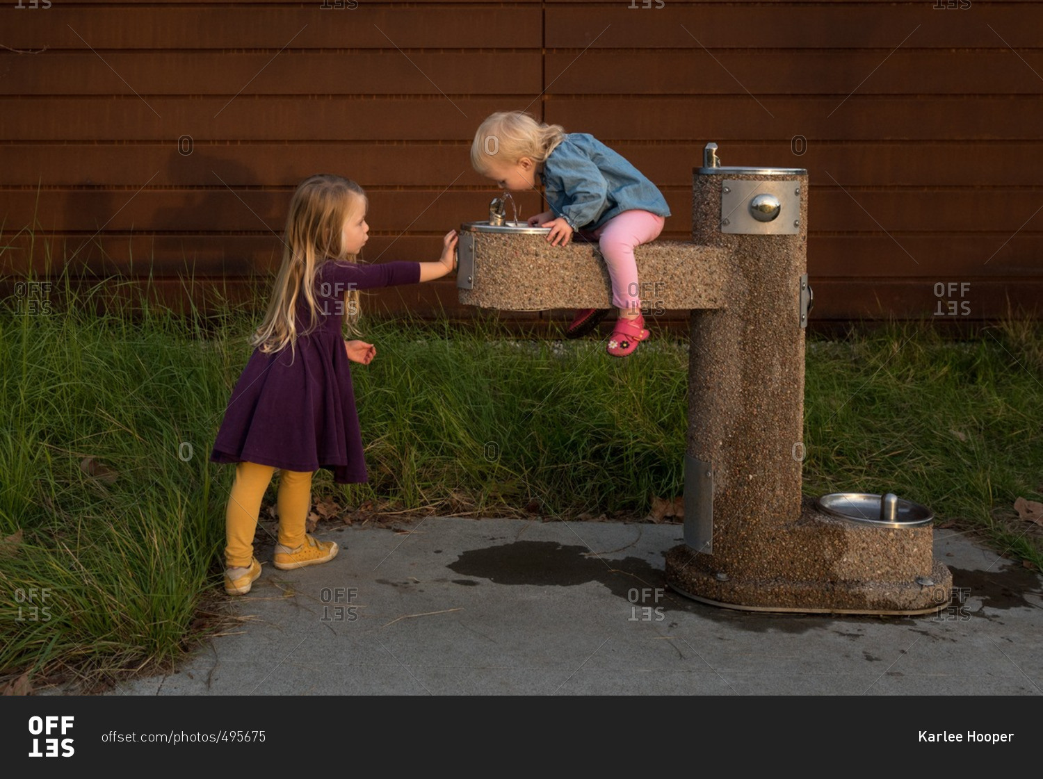 Girls playing around drinking fountain