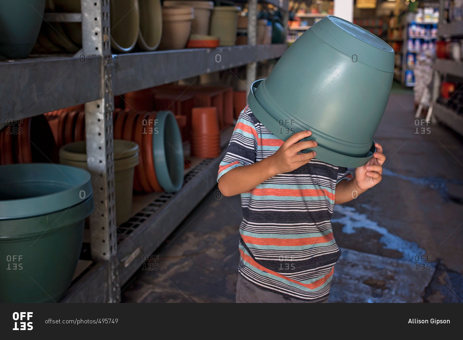 Little boy with large planter pot covering his head