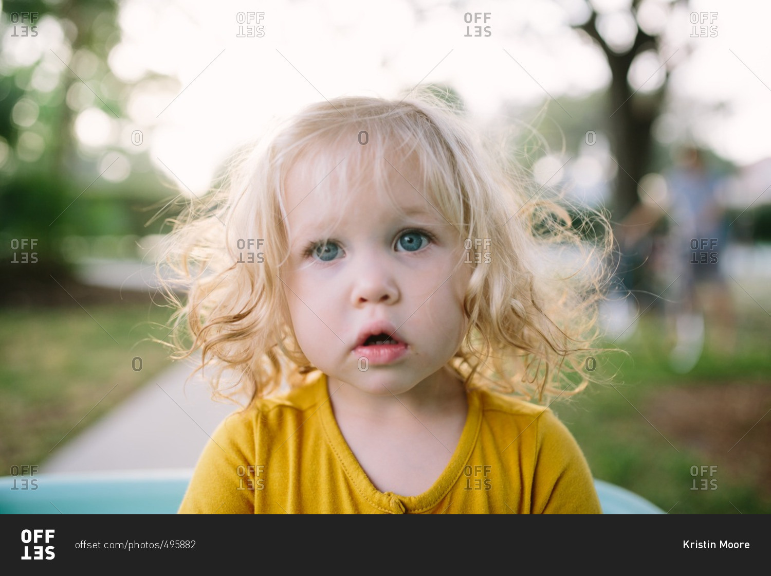Portrait of a toddler girl with curly blond hair and blue eyes stock