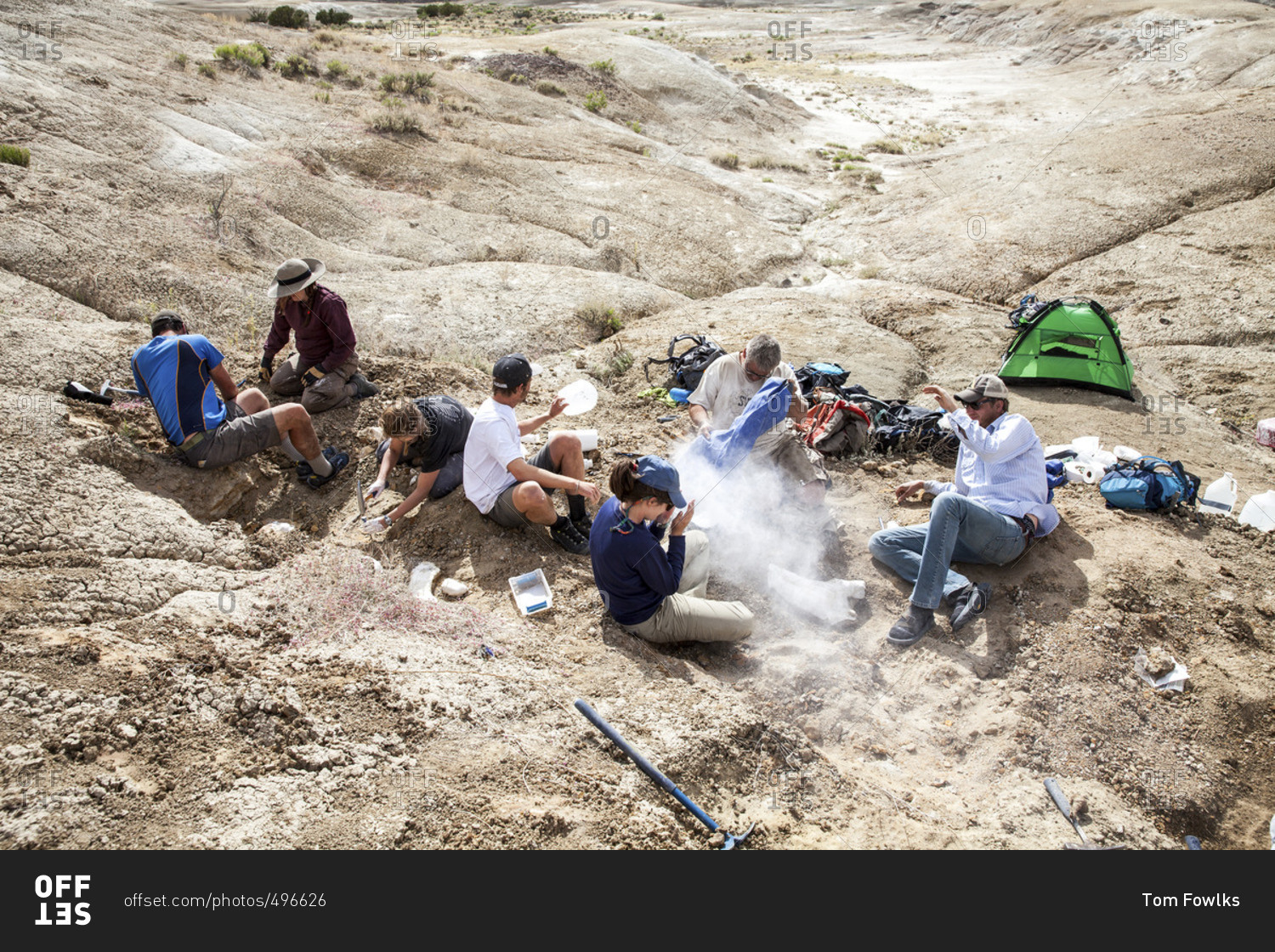 Group of people digging in the desert stock photo - OFFSET