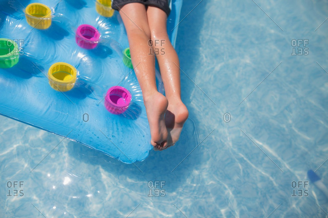 Boy's legs lying on pool float