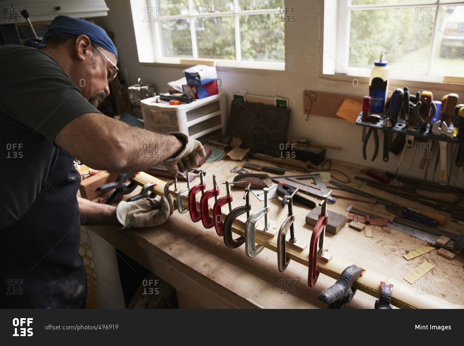A bow maker working on a wooden bow in his shaping the wood by