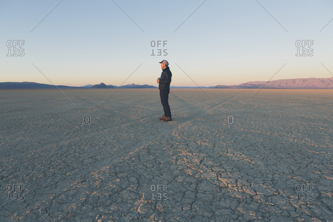 Man standing in vast desert playa at dawn, Black Rock Desert, Nevada