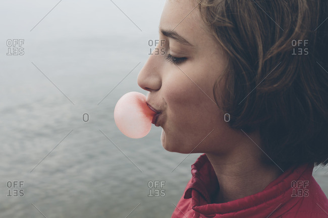 Eleven year old girl blowing bubble gum bubble