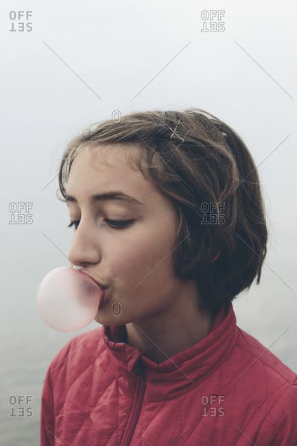 Eleven year old girl blowing bubble gum bubble