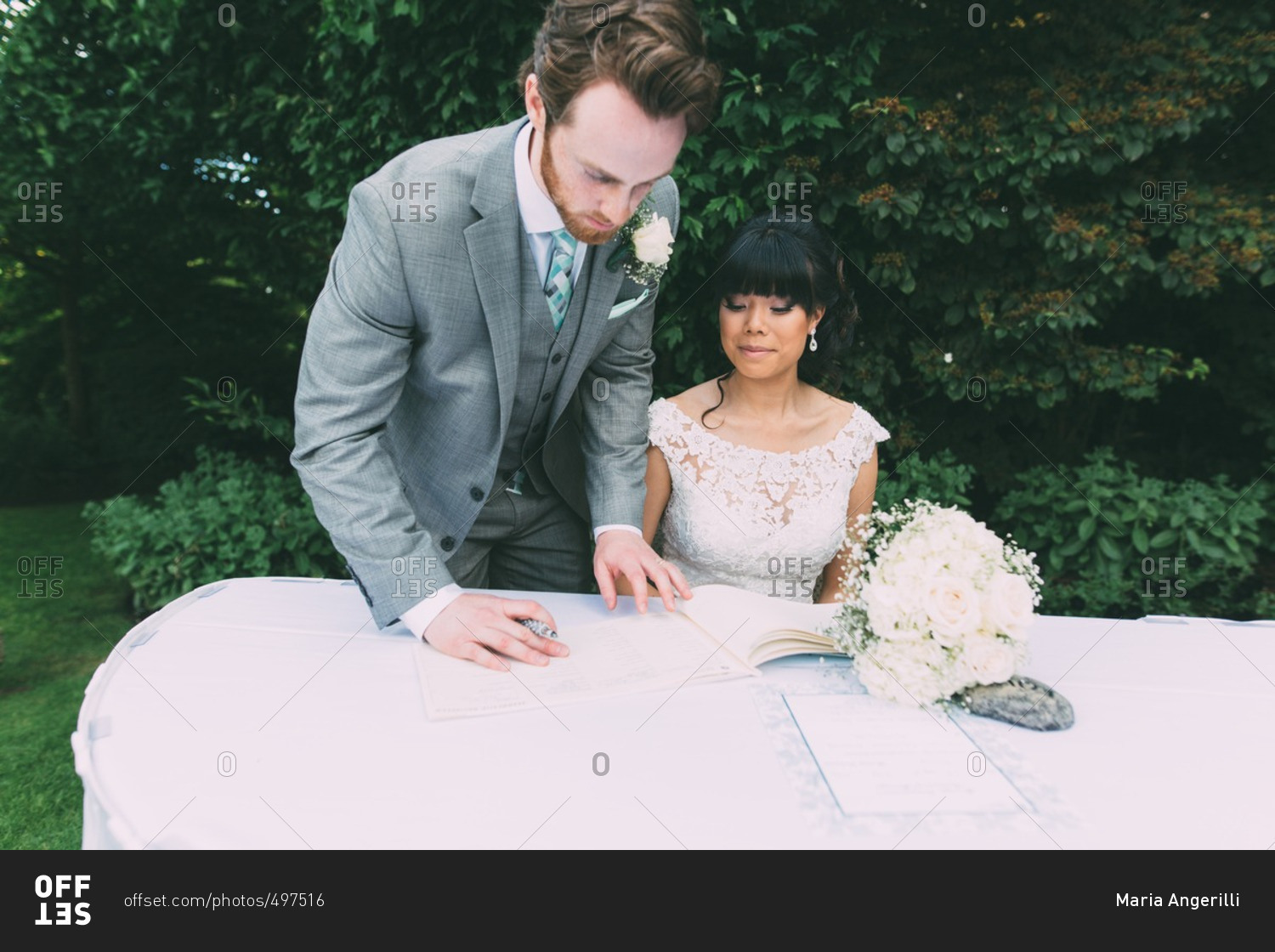 Newlywed couple signing the marriage certificate on their wedding day