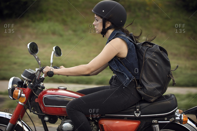 Side View Of Woman Riding Motorcycle On Road Stock Photo OFFSET