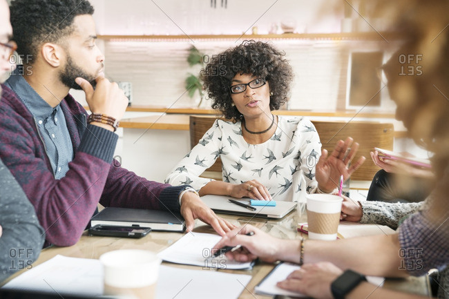 Business People Looking At Woman Explaining In Meeting Room