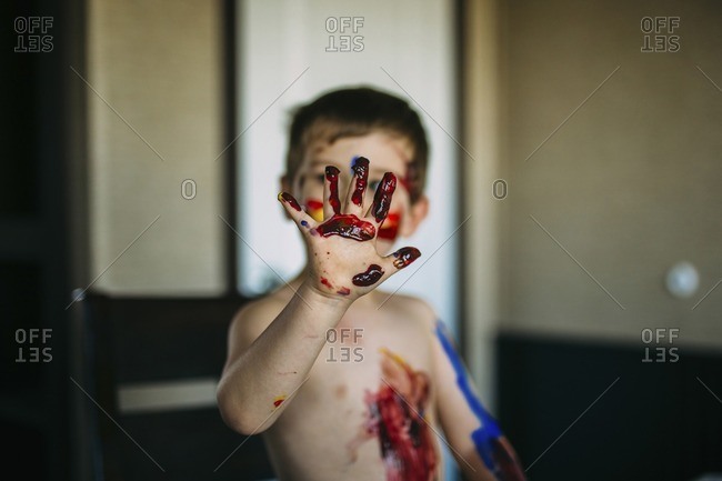 Shirtless boy showing messy hand