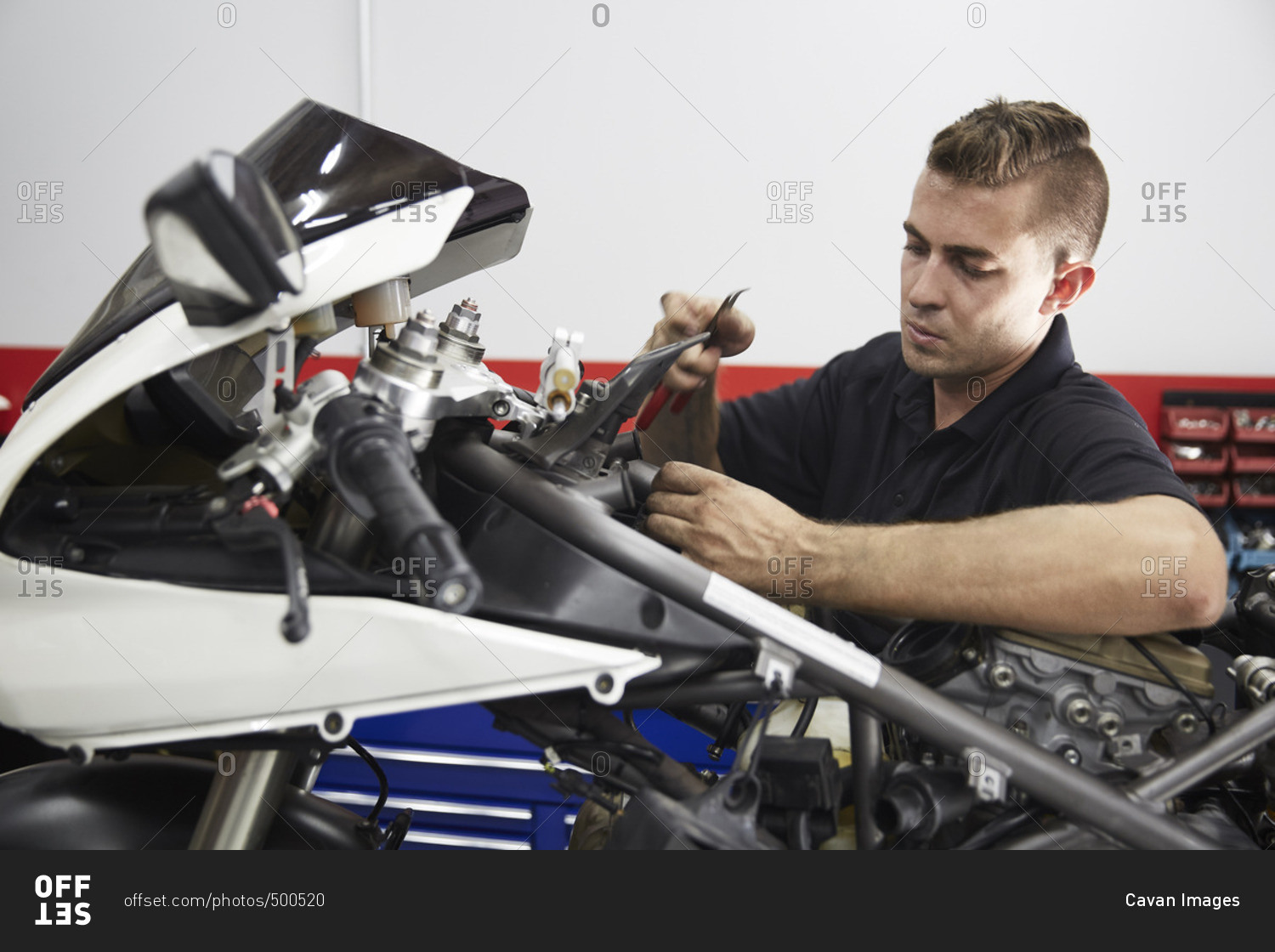 Worker repairing motorcycle in workshop