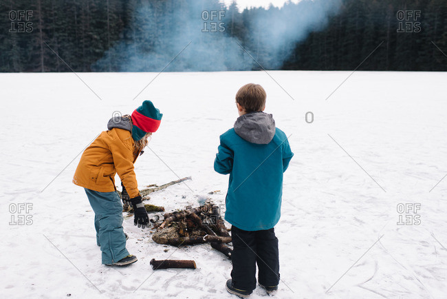 Kids making fire in snowy field