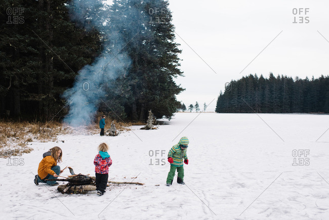 Kids by fire in snowy field