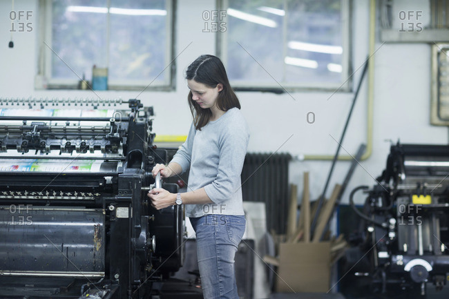 Print worker adjusting printing machine in an industry, Freiburg im Breisgau, Baden-Wurttemberg, Germany