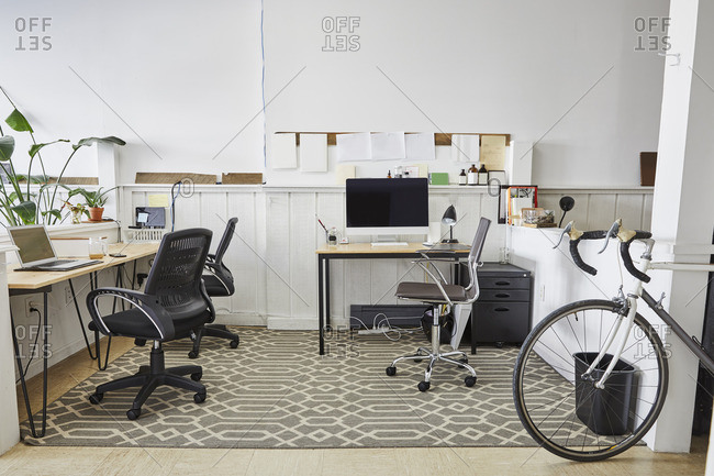 Chairs and computer against white wall in creative office