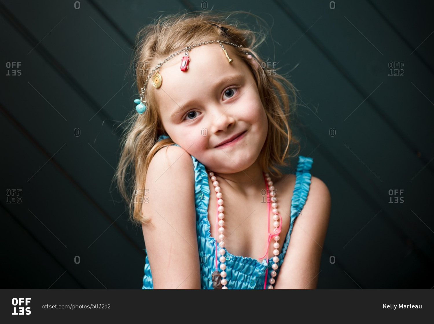 Cute young girl wearing charm necklace as headband
