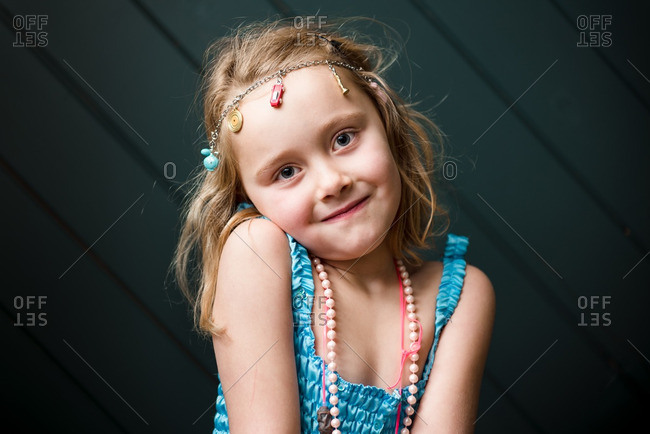 Cute young girl wearing charm necklace as headband