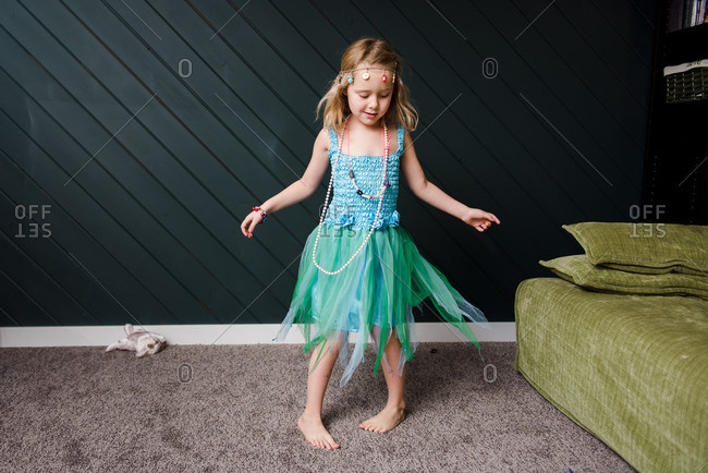 Girl playing dress up and dancing in living room