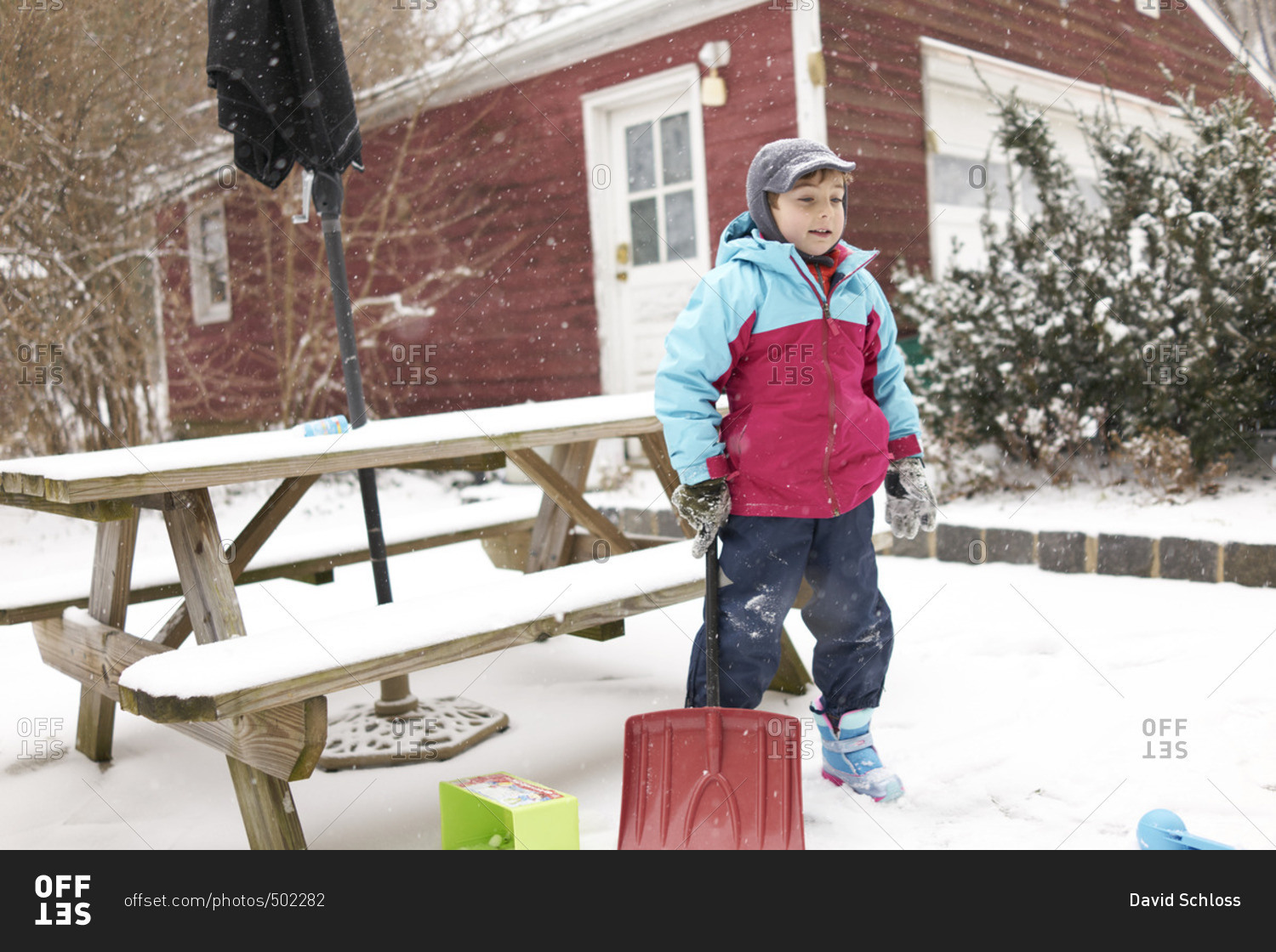 Boy with snow shovel on patio