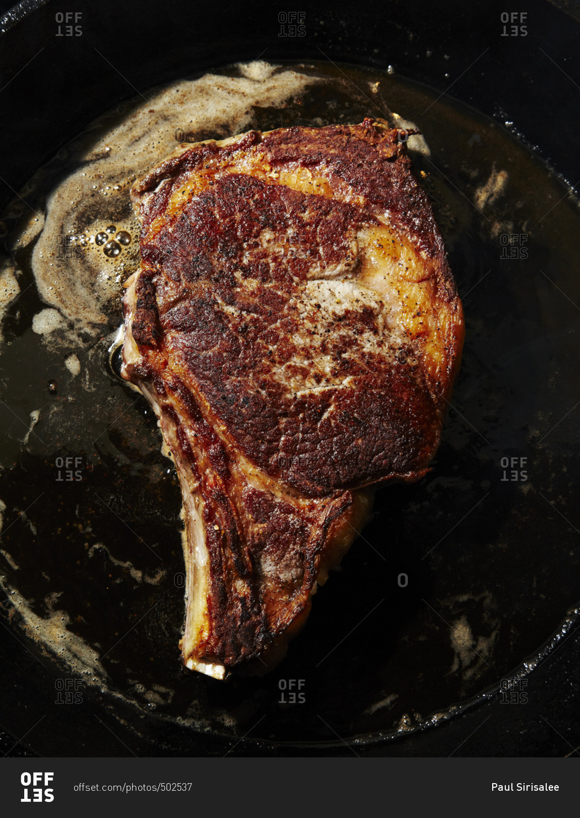 Porterhouse steak being cooked in a cast iron skillet stock photo OFFSET