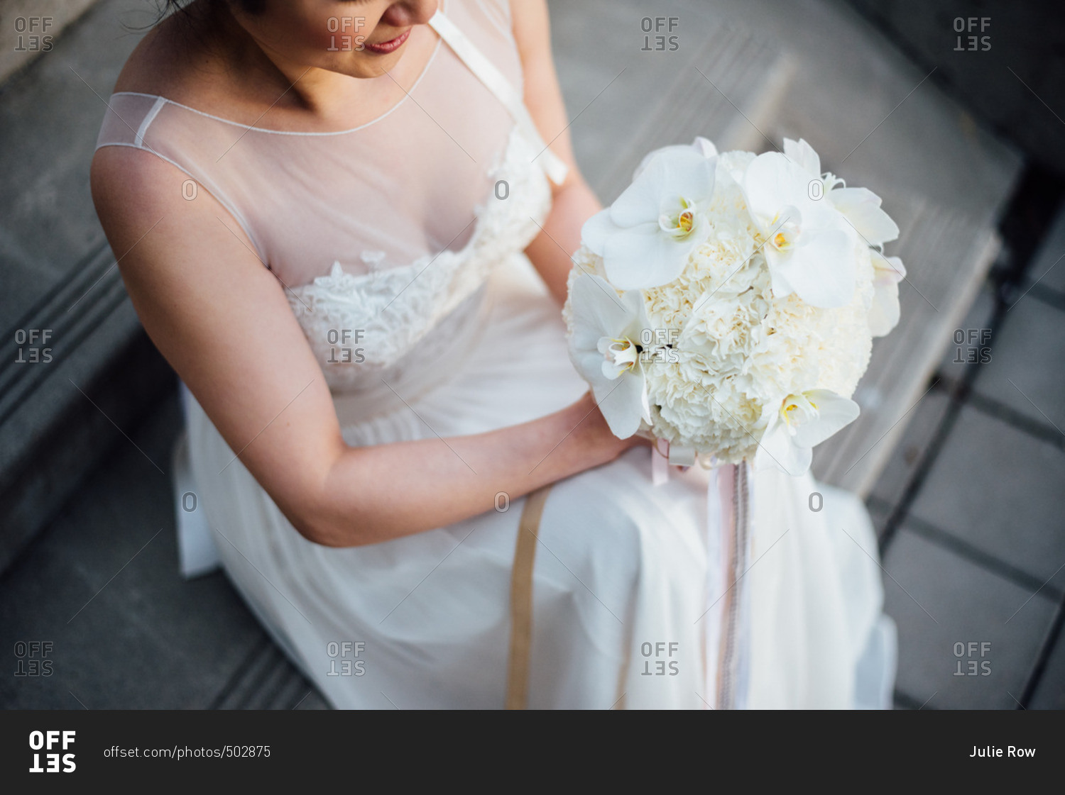 Bride on steps with white flowers