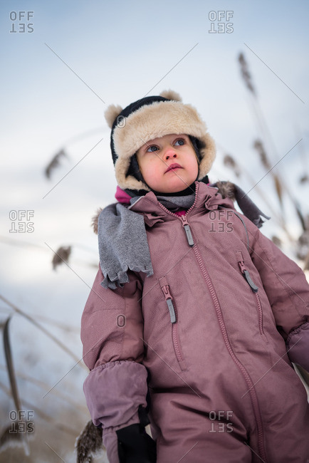 Portrait of a toddler girl wearing an anorak and hood outside