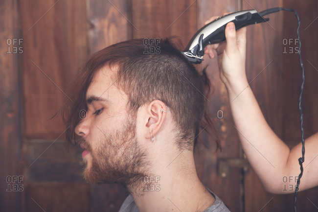 Young Man Getting A Haircut By His Girlfriend With Hair
